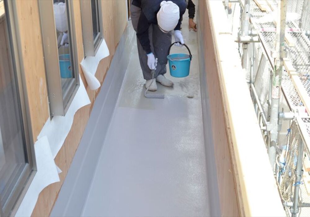 ベランダ床の防水工事を行う職人jpg