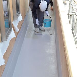 ベランダ床の防水工事を行う職人jpg